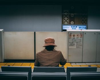 Rear view of man sitting on chair