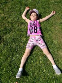 High angle view of girl lying on grassy field