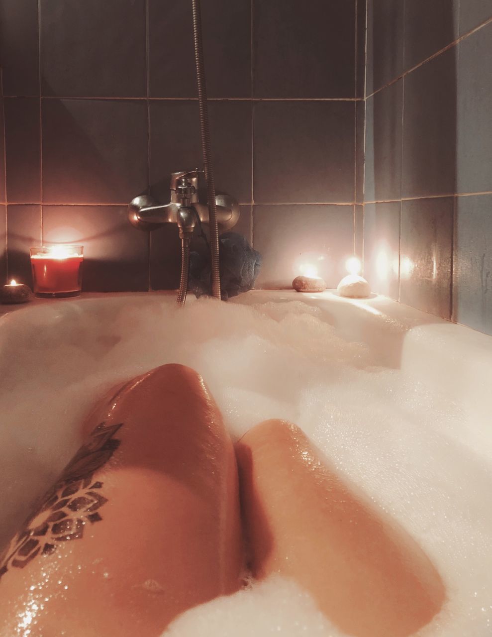 LOW SECTION OF MAN RELAXING IN BATHTUB