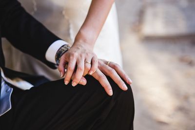 Midsection of couple holding hands