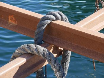 Close-up of rope tied to boat moored at pier