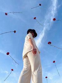 Low angle view of girl with flowers floating creating a magic local and surreal image