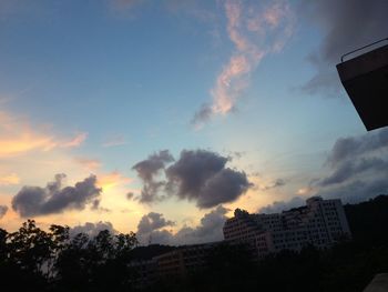 Low angle view of buildings against cloudy sky