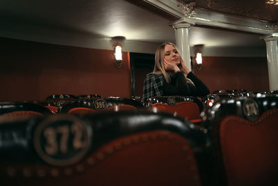 Portrait of young woman looking down at theatre 