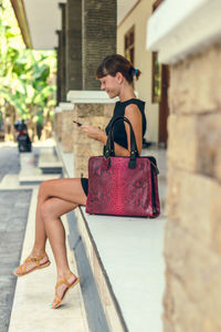 Side view of woman sitting outdoors