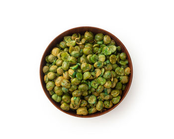 High angle view of green peas in bowl on white background