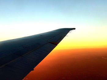 Low angle view of airplane wing against sky