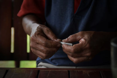 Midsection of man sitting on table