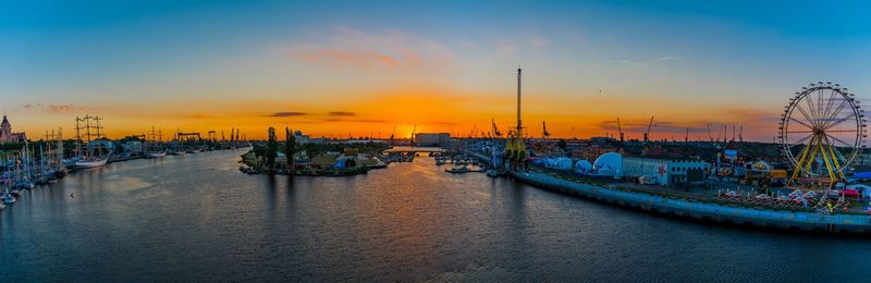 Boats moored at harbor during sunset