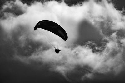 Low angle view of person paragliding against sky