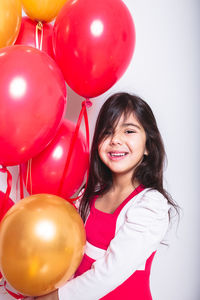 Portrait of a smiling young woman with balloons