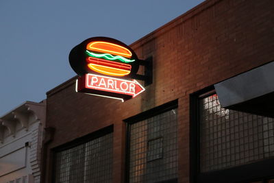 Low angle view of illuminated text on building at night