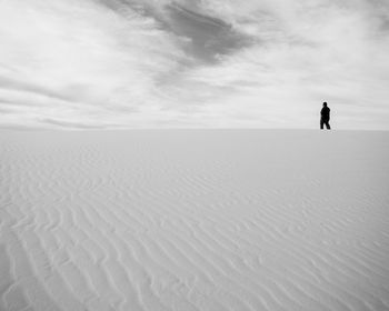 Rear view of man running on landscape against cloudy sky