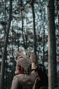 Bride and bridegroom holding hands while standing in forest