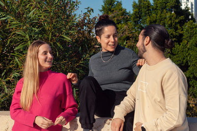 Portrait of smiling friends standing against plants