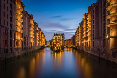 Canal passing through city buildings at night