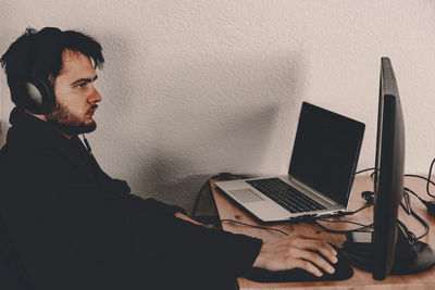 Young man using mobile phone while sitting on table