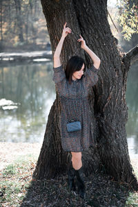 Woman standing by tree trunk