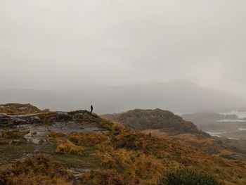 Man standing on mountain against sky