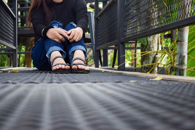 Low section of man sitting on footpath