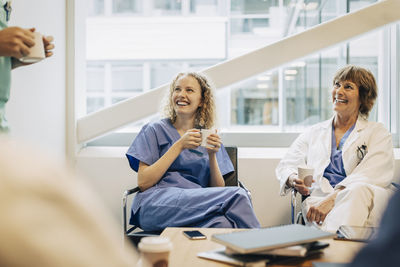 Happy female healthcare workers having coffee during break in hospital