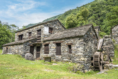 Stone watermill with wooden wheel in an abandoned mountain village in the alps