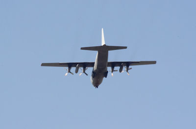 Low angle view of airplane against clear blue sky