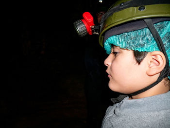 Boy inside the cave wearing helmet with copy space.