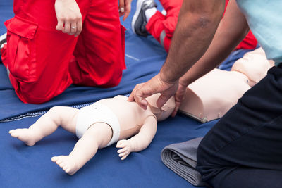 Volunteers giving first aid training with mannequin