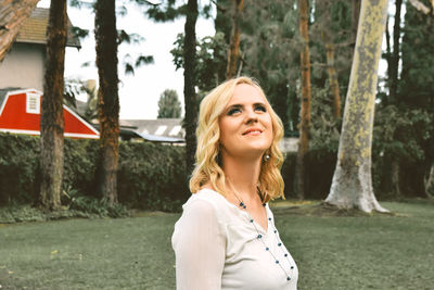 Smiling mid adult woman looking up in park