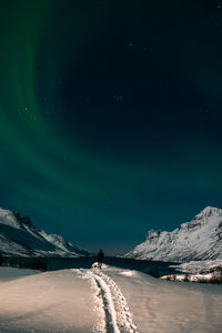 Scenic view of snowcapped mountains against sky at night