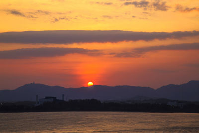 Scenic view of silhouette mountains against romantic sky at sunset