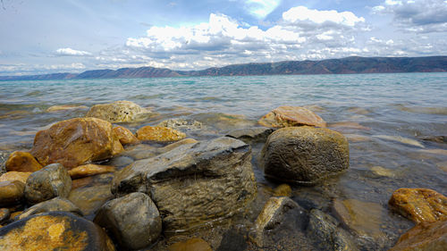 Rocks in sea against sky