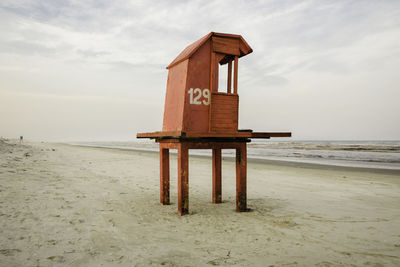 Lifeguard hut on beach against sky