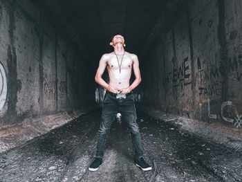 Portrait of young man standing in tunnel