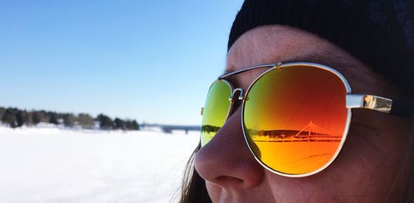 Close-up of woman wearing sunglasses against sky