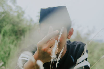 Close-up of man holding hands against window