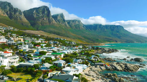 High angle view of townscape by sea against sky