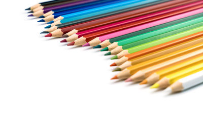 High angle view of colored pencils against white background