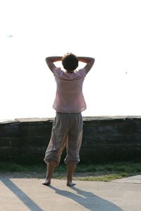 Rear view of woman standing against clear sky