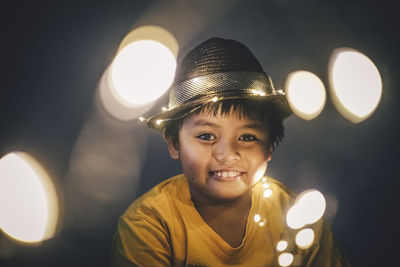 Portrait of boy amidst illuminated lights