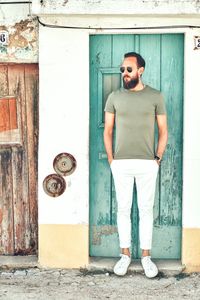 Portrait of young man standing by door