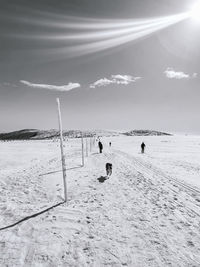 People on beach against sky during winter