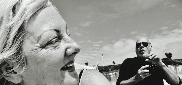 Low angle view of happy couple against sky during sunny day