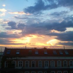 Low angle view of building against cloudy sky at sunset