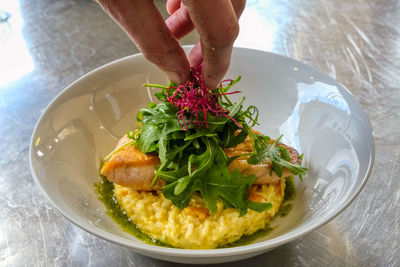 Close-up of hand holding food in plate