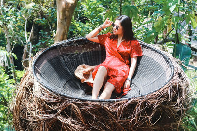 High angle view of woman sitting in wicker container