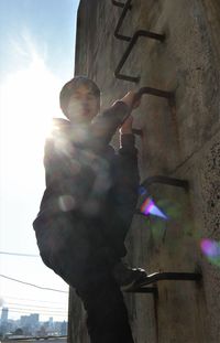 Low angle view of boy standing against wall