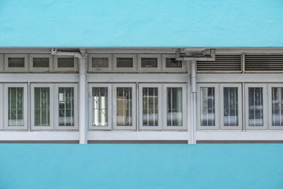 Reflection of building in swimming pool against blue sky