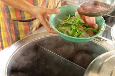 Midsection of man preparing food in bowl